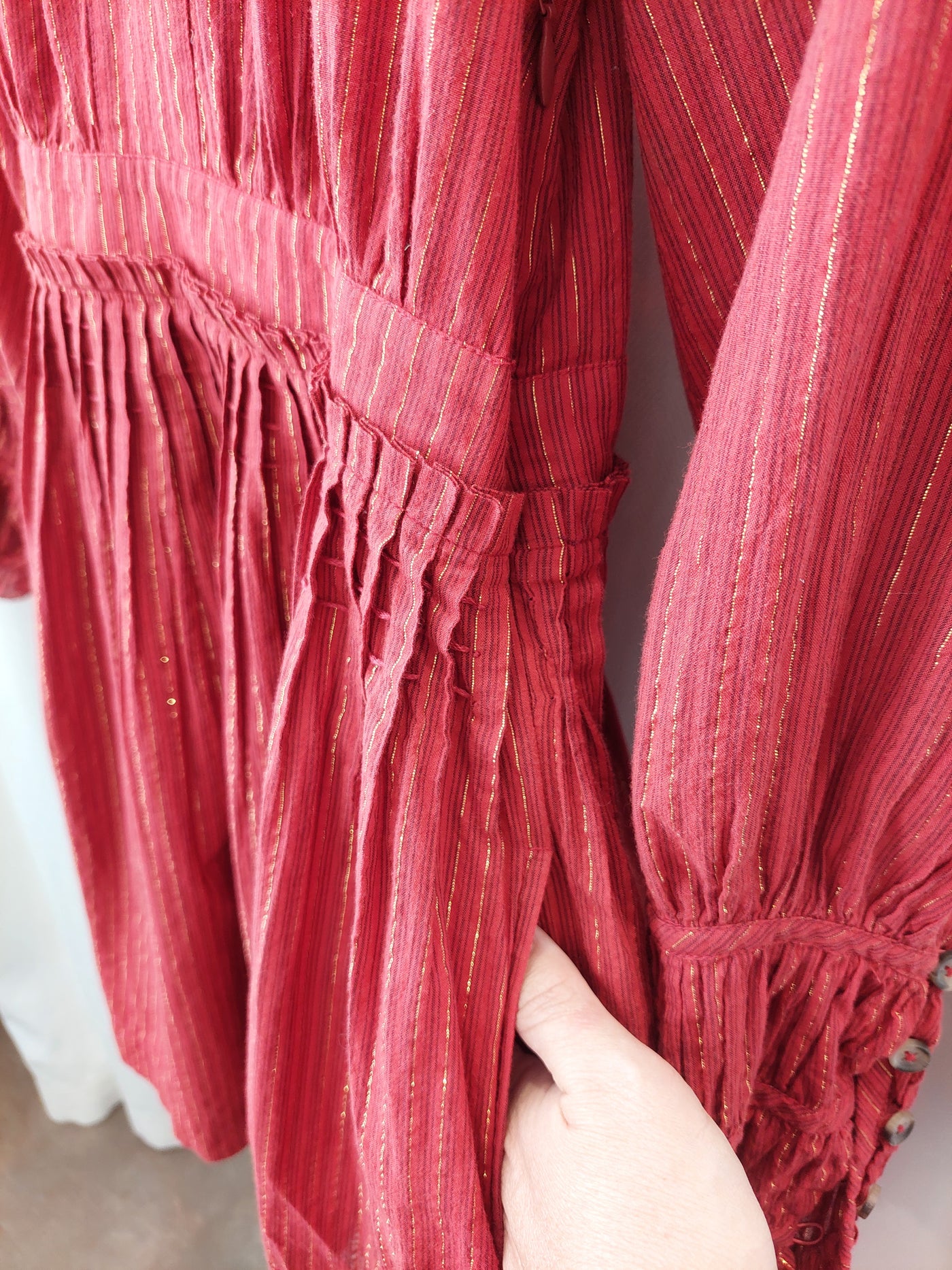 Close-up of a red pleated garment with a blurred background
